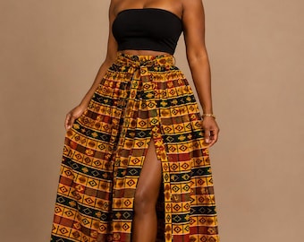May include: A black strapless tube top paired with a high-waisted maxi skirt featuring a vibrant geometric pattern in shades of yellow, red, green, and black. The skirt includes a front slit and a matching tie belt, complemented by a matching headband.