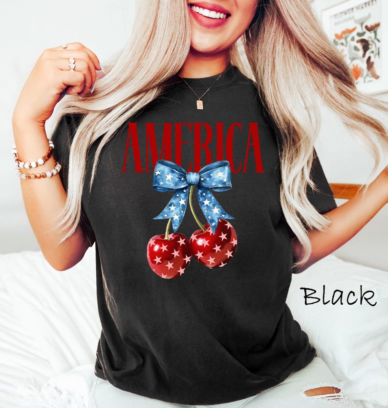 May include: Black t-shirt with a red, white, and blue cherry design and the word "AMERICA" printed on the front.