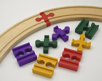 May include: Wooden toy train track with colorful plastic connectors in red, purple, green, and yellow. The track is curved, and the connectors are in various shapes, including cross and block designs.
