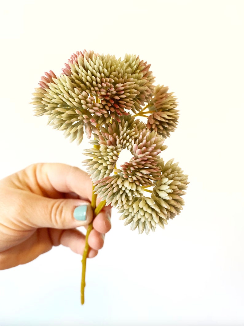以下が含まれることがあります： 緑とピンクの花が咲いた人工多肉植物の束。茎は黄色で、花は集まって咲いています。