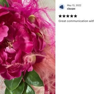 Peut inclure: Un chapeau de paille blanc avec une fleur de pivoine rose et des plumes roses.