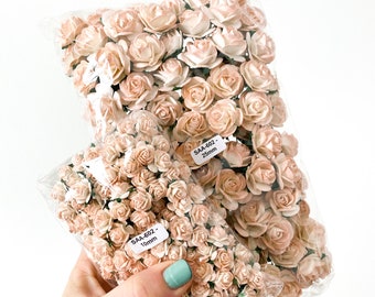 May include: Two bags of peach-colored paper roses. The smaller bag has a label that reads "SAA-602 - 10mm". The larger bag has a label that reads "SAA-602 - 25mm".