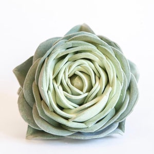 May include: A single, artificial succulent flower in a light green color. The flower is made of fabric and has a realistic appearance.