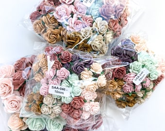 May include: Three bags of assorted paper flowers in various shades of brown, pink, green, and purple. The flowers are in different sizes, with the largest being 20mm and the smallest being 10mm. The bags are labeled with the size of the flowers and the product code "SAA-046".