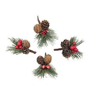 May include: Four pine cone sprigs with red berries and bells. Each sprig has a cluster of pine cones, red berries, and a small bell. The sprigs are arranged in a square pattern on a white background.