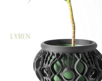 May include: A black decorative plant pot with a unique openwork design, holding a green plant. The pot has a rounded shape and a contrasting green interior. The word "LYREN" is printed in green.