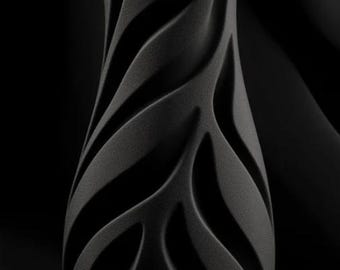 May include: A black vase with a textured surface and a unique, flowing design. The vase has a slender, elongated shape with a series of curved, leaf-like patterns. The word "INFERNO" is written in red at the bottom of the vase.