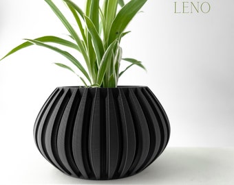 May include: A black, ribbed, spherical planter pot holding a green and white plant. The pot has a modern design with vertical grooves. The word "LENO" is printed in a light green color on the right side of the image.