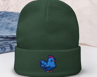 Può includere: Un berretto verde scuro con un pollo pixelato blu ricamato sul davanti.