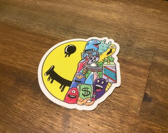 May include: A yellow smiley face sticker with a black dripping smile. The sticker is filled with colorful cartoon characters, including a blue alien, a yellow monster, a red monster, a purple monster, and a dollar sign.