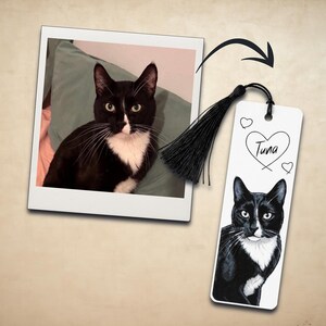 May include: A rectangular white bookmark featuring a custom illustration of a black and white tuxedo cat. The bookmark includes a black tassel, a heart outline, and the name Tuna written in black script. A square photo of the same cat is included.