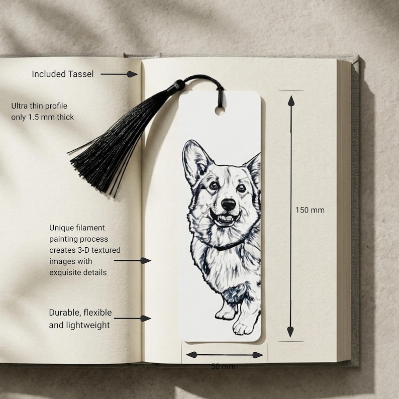 May include: A white rectangular bookmark featuring a black and white line drawing of a Corgi dog. The bookmark includes a black tassel attached through a hole at the top. It measures 150 mm in height and 50 mm in width, with a 1.5 mm thickness.