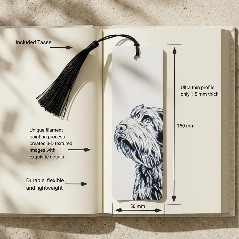May include: A rectangular white bookmark featuring a detailed black and white illustration of a dog's head. The bookmark includes a black tassel attached to the top hole. It measures 150 mm in height, 50 mm in width, and 1.5 mm in thickness.