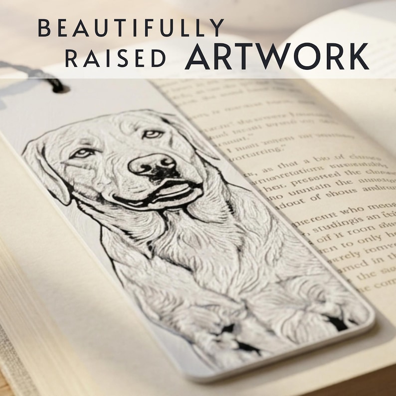 May include: A white rectangular bookmark featuring a raised, black-ink line drawing of a Labrador retriever dog. The bookmark has a black string at the top and displays the text BEAUTIFULLY RAISED ARTWORK at the top of the image.