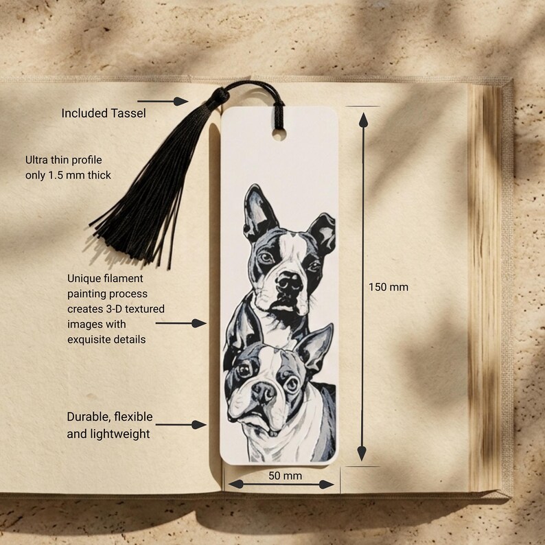 May include: A rectangular bookmark measuring 150 mm by 50 mm and 1.5 mm thick, featuring a black and white illustration of two Boston Terrier dogs. The bookmark includes a black tassel attached through a hole at the top center.