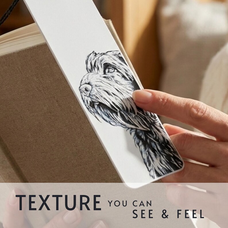 May include: A white rectangular bookmark featuring a detailed black and white ink illustration of a dog's head. The bookmark is placed inside a tan book. The text at the bottom of the image reads: TEXTURE YOU CAN SEE & FEEL.