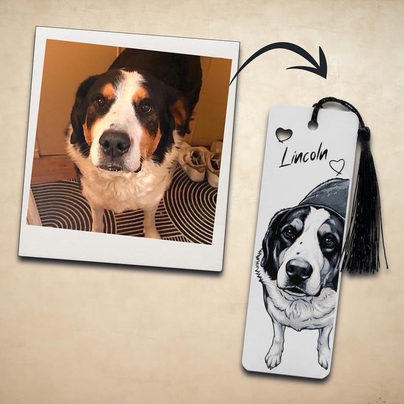 May include: A rectangular bookmark featuring a black and white illustration of a dog with a black hat, the name Lincoln, and two heart icons. A black tassel is attached to the top hole. Next to it is a square photograph of the same dog.
