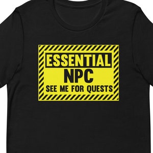 Puede incluir: Camiseta negra con una señal de advertencia amarilla y negra que dice "Essential NPC See Me For Quests".