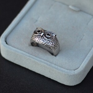 May include: A silver owl ring in a light gray velvet ring box.