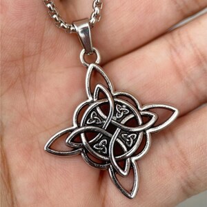 May include: Silver Celtic knot pendant necklace. The pendant is a complex design of interwoven knots, creating a intricate and beautiful pattern.