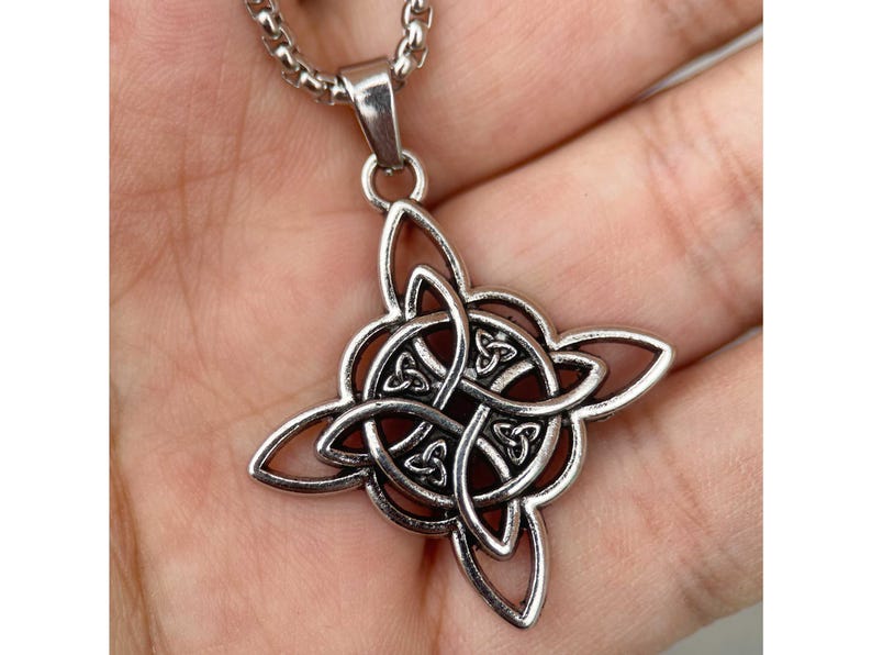 May include: Silver Celtic knot pendant necklace. The pendant is a complex design of interwoven knots, creating a intricate and beautiful pattern.