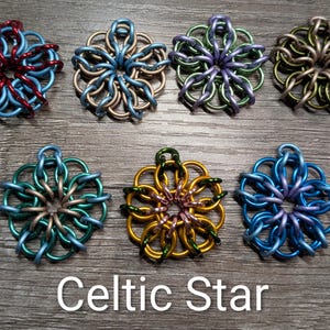 May include: Seven colorful Celtic Star pendants in various shades of blue, green, purple, gold, and silver. Each star-shaped pendant is crafted from interlocking metal rings. The text "Celtic Star" is displayed at the bottom.
