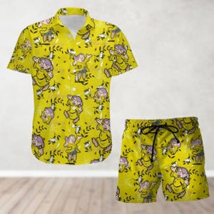 May include: A yellow button-down shirt and matching shorts with a pattern of cartoon dwarfs in yellow and purple. The dwarfs are wearing yellow hats and have white beards.