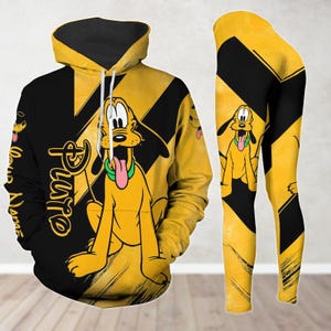 Puede incluir: Un conjunto de sudadera y leggings amarillo y negro con una imagen de dibujos animados de Pluto, el perro de Disney. El texto "Pluto" está impreso en la sudadera.