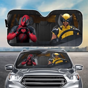 May include: A car sunshade featuring Deadpool and Wolverine. Deadpool is making a heart shape with his hands and Wolverine is driving a car. The sunshade is black with a wood grain pattern.