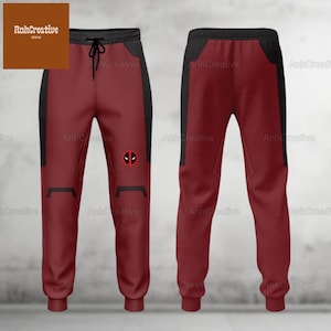 Pode incluir: Calças de moletom vermelhas e pretas com um logotipo do Deadpool na perna esquerda. As calças de moletom têm cintura com cordão e um caimento relaxado.