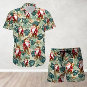 Könnte beinhalten: Ein tropisches Hemd mit Knöpfen und passende Shorts mit einem sich wiederholenden Muster eines Cartoon-Zwergs mit roter Mütze und Bart, der vor grünen tropischen Blättern auf beigefarbenem Hintergrund steht.