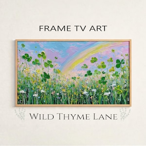 Könnte beinhalten: Ein gerahmtes Kunstwerk mit einer lebendigen Wiesenlandschaft, die grüne Kleeblätter, Wildblumen und einen Regenbogen vor einem pastellfarbenen Himmel zeigt. Der Text "FRAME TV ART" und "WILD THYME LANE" sind ober- und unterhalb des Kunstwerks zu sehen.