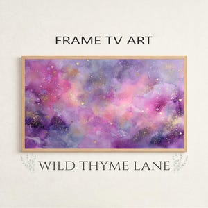 Peut inclure: Une œuvre d'art encadrée avec un design à l'aquarelle dans des tons de violet, de rose et d'or. L'œuvre présente une composition abstraite avec le texte "FRAME TV ART" en haut et "WILD THYME LANE" en bas.