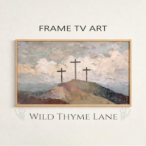 May include: Framed art print featuring three dark crosses atop a hill, set against a cloudy sky. The artwork has a textured, painterly style with muted tones of beige, gray, and brown. The text "FRAME TV ART" and "WILD THYME LANE" are displayed.