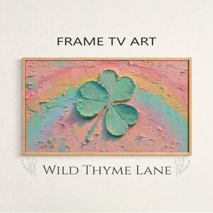 Peut inclure: Une œuvre d'art encadrée avec un fond texturé et coloré et un grand trèfle à trois feuilles au centre. Le fond présente des couleurs pastel, et le texte "FRAME TV ART" et "WILD THYME LANE" sont affichés.