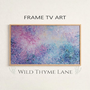 Peut inclure: Impression d'art abstrait dans un cadre en bois. L'œuvre présente un mélange de teintes roses, violettes et bleues, créant un aspect doux et texturé. Le texte "FRAME TV ART" est en haut et "WILD THYME LANE" en bas.