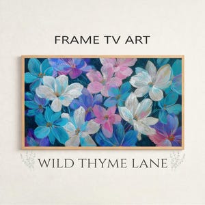May include: A framed floral art piece featuring a vibrant display of flowers in shades of blue, white, and pink. The artwork is set against a dark background and framed in a light brown wooden frame. The text "FRAME TV ART" and "WILD THYME LANE" are displayed.