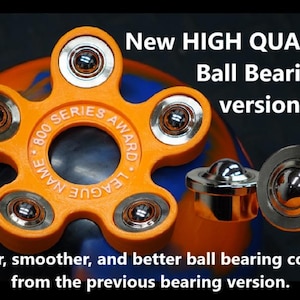 May include: Orange fidget spinner with ball bearings and the text "800 SERIES AWARD LEAGUE NAME" on the center. The spinner is on a blue and orange background.  New HIGH QUALITY Ball Bearing version. Quieter, smoother, and better ball bearing compare from the previous bearing version.