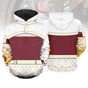May include: White and burgundy hoodie with a black-lined hood. The design features gold accents, a patterned lower section, and a detailed front and back. The hoodie has a drawstring and a comfortable fit.