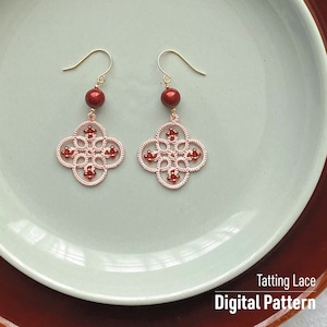 Può includere: Un paio di orecchini in pizzo tatting rosa e rosso con una perla rossa in cima a ogni orecchino. Gli orecchini sono su un piatto blu chiaro con il testo "Tatting Lace Digital Pattern" sotto gli orecchini.