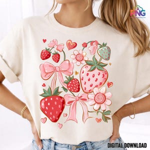 May include: Cream-colored t-shirt featuring a whimsical strawberry design. The design includes pink bows, hearts, and strawberries in various sizes and shades of red and pink. The words "DIGITAL DOWNLOAD" are at the bottom.