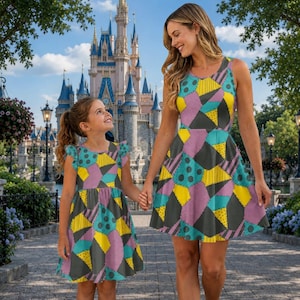 May include: Two sleeveless dresses featuring a patchwork pattern of dark gray, yellow, light blue, and purple shapes with polka dots and stripes. The dresses have a flared skirt and a fitted bodice, showcasing a colorful, geometric, multi-patterned design.