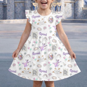 May include: White dress with a colourful pattern featuring a purple dragon, rainbows, and the word "Epcot". The dress has flutter sleeves and a flared skirt. The phrase "one little spark" is also visible.