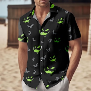 May include: Black short-sleeved shirt with a Halloween design. The shirt is patterned with green jack-o'-lantern faces and grey bats. It has a classic collar and is worn with white trousers. The shirt is buttoned up.