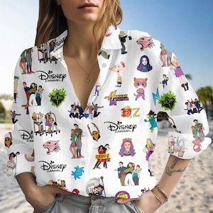 Może przedstawiać: Biała koszula zapinana na guziki z postaciami i logo Disney Channel. Koszula ma długie rękawy i jest pokryta kolorową grafiką z różnych programów Disneya. Loga obejmują "Disney Channel", "Hannah Montana" i "Camp Rock".