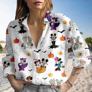 May include: White button-down shirt featuring a Halloween-themed pattern with cartoon characters, pumpkins, bats, ghosts, and spiderwebs. The long-sleeved shirt has a collared neckline and buttoned cuffs. The design includes Mickey and Minnie Mouse in Halloween costumes.