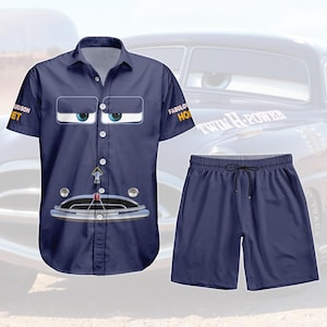 May include: Navy blue button-up shirt and matching shorts set. The shirt features a cartoon car face design with the text "HUDSON JET" and "FABULOUS HORN". The shorts have a drawstring waist. The set is a fun, casual outfit.