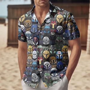 May include: Short-sleeved shirt with a repeating pattern of Mandalorian helmets in various colours, including gold, blue, green, and silver, on a dark background. The shirt has a classic collar and is worn by a person.