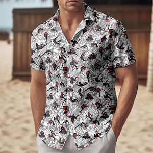 May include: White short-sleeve button-down shirt featuring a repeating pattern of black and red figures on a white background. The shirt has a classic collar and is worn with light gray pants. The design is reminiscent of a comic book.