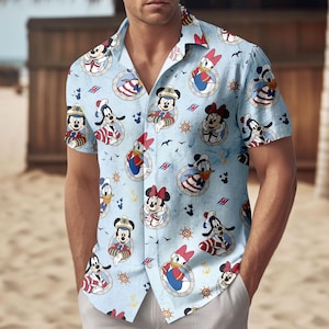 May include: Light blue button-down shirt featuring a repeating pattern of cartoon characters in nautical-themed designs. The characters include Mickey Mouse, Minnie Mouse, Donald Duck, and Goofy, each in sailor attire. The shirt has short sleeves.